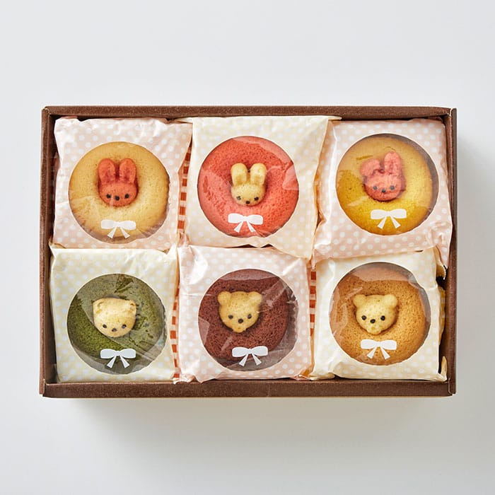 Box of 12 individually wrapped animal-shaped sponge cakes in assorted flavors including strawberry, plain, banana, chocolate, matcha, and caramel. Shaped like cute rabbits and bears, neatly arranged in a rectangular gift box measuring 21 × 30.2 × 8.5 cm.